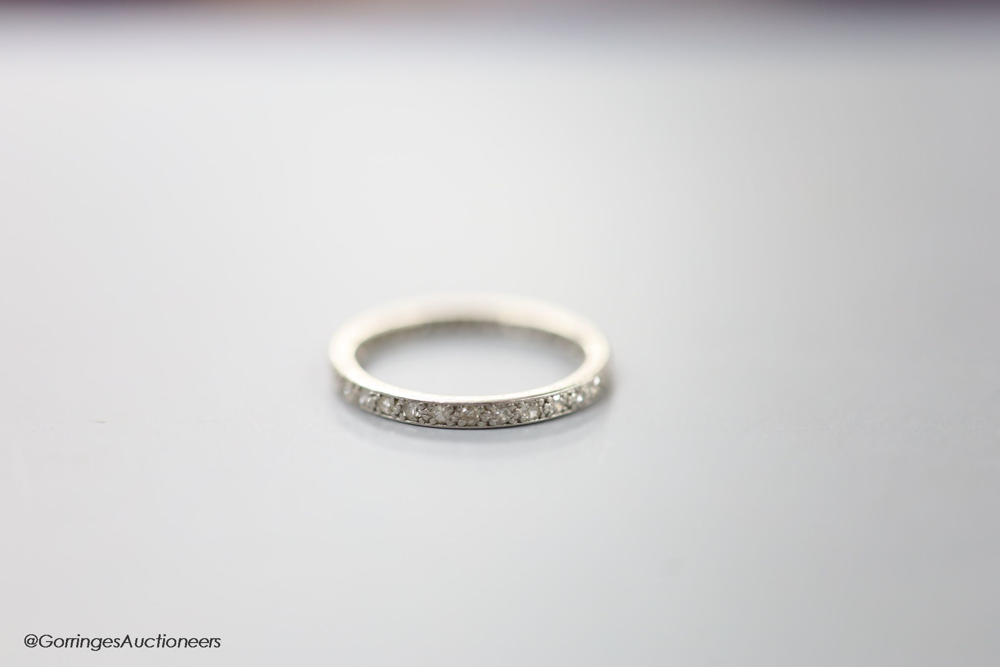 A white metal and diamond chip set full eternity ring, size L, gross 2.2 grams.